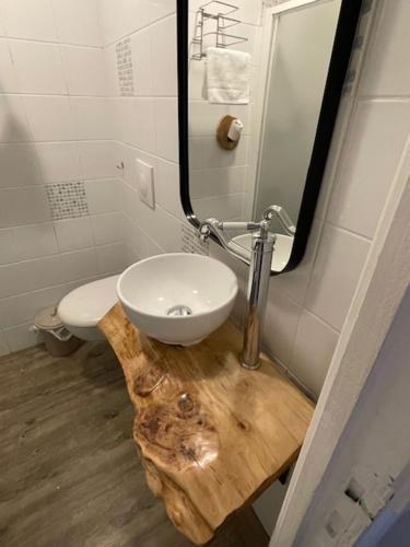 a bathroom with a sink and a toilet and a mirror at Hotel de la plage in Banyuls-sur-Mer