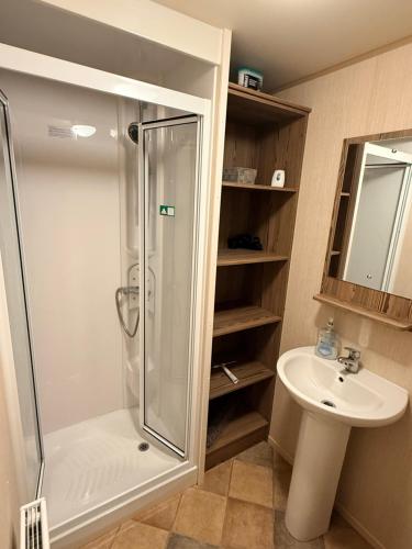 a bathroom with a shower and a sink at haggerston castle lakeside east 27 in Goswick Station