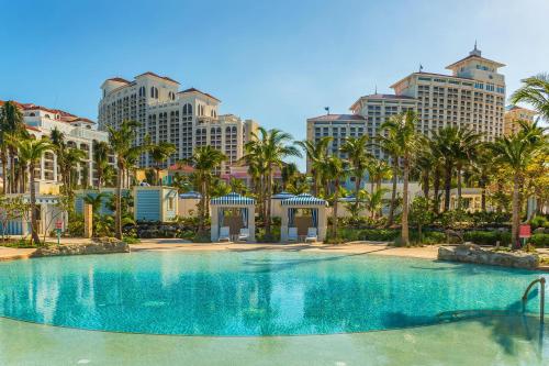 a large swimming pool with palm trees and buildings at Grand Hyatt Baha Mar in Nassau