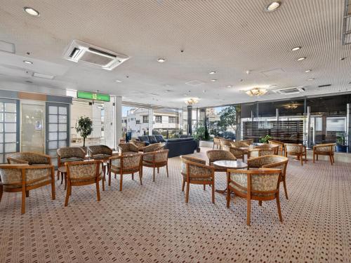 a lobby with tables and chairs in a building at Hitachi Ocean View HOTEL and RESORT in Hitachi