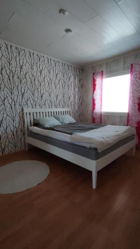 a bedroom with a bed in a room with a window at kelankaari in Kankaanpää