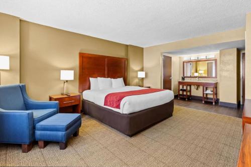 a hotel room with a bed and a blue chair at Comfort Inn & Suites Lakeland North I-4 in Lakeland