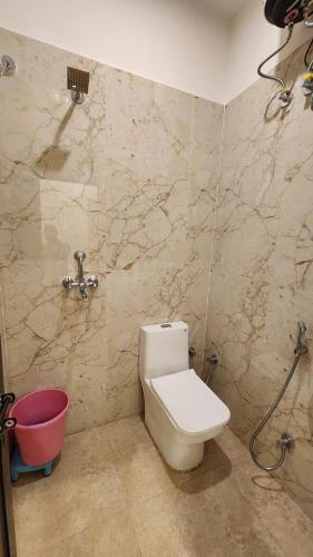 a bathroom with a toilet and a shower and a bucket at Hotel RK Heritage in Varanasi