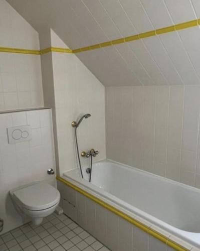 a bathroom with a toilet and a bath tub and a toilet at Dünenhaus 2 Schlafzimmer in Timmendorfer Strand