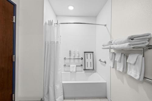 a white bathroom with a shower and white towels at Spark by Hilton Stillwater in Stillwater
