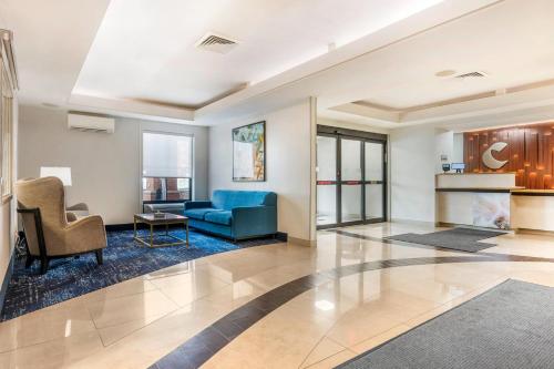 a living room with a blue couch and chairs at Comfort Inn & Suites Saint Louis Lafayette Square in Saint Louis