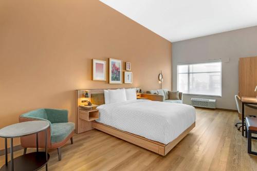 a bedroom with a bed and a table and a chair at Cambria Hotel Euless - DFW Airport South in Euless