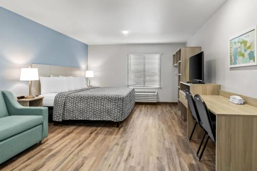 a small hotel room with a bed and a couch at WoodSpring Suites Washington Meadowlands PA in Washington