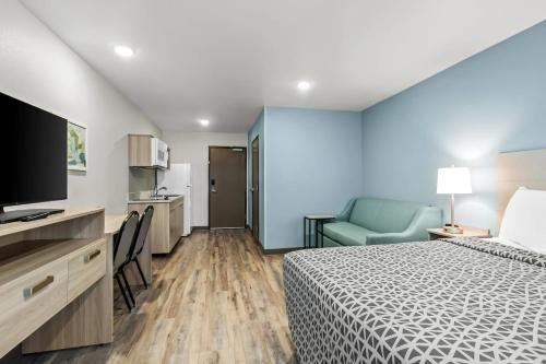 a hotel room with a bed and a television at WoodSpring Suites Washington Meadowlands PA in Washington