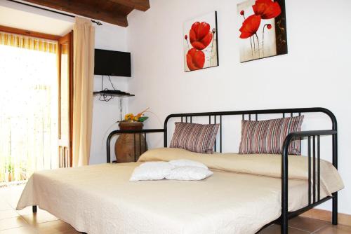 two beds in a bedroom with red flowers on the wall at Guest House La Casetta in Piazza Armerina