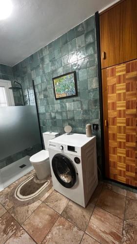 a bathroom with a washing machine and a toilet at Villa Òdena in Odena