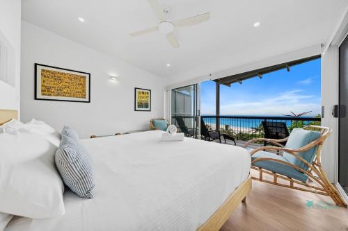 a bedroom with a white bed and a view of the ocean at Cylinder Cove 9 in Point Lookout