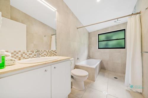 a bathroom with a sink toilet and a window at Cylinder Cove 9 in Point Lookout