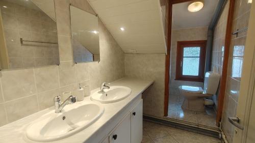 a bathroom with two sinks and a toilet at Duplex avec vue au centre de Bussang in Bussang