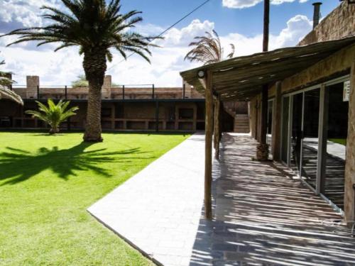 a porch of a house with a palm tree at Victory Towers in Bloemhof