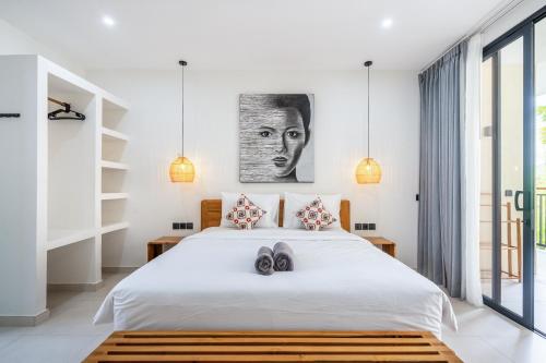 a bedroom with a bed with two slippers on it at Dreamland Suites - Walk to Dreamland Beach in Uluwatu
