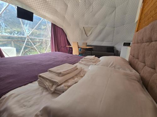a bedroom with a bed with towels on it at Glamping Machakhela 2 in Ch'ik'unet'i