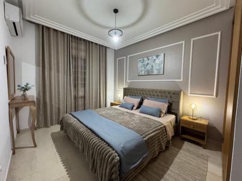 a bedroom with a bed with blue sheets and blue pillows at La perle bleue in La Goulette