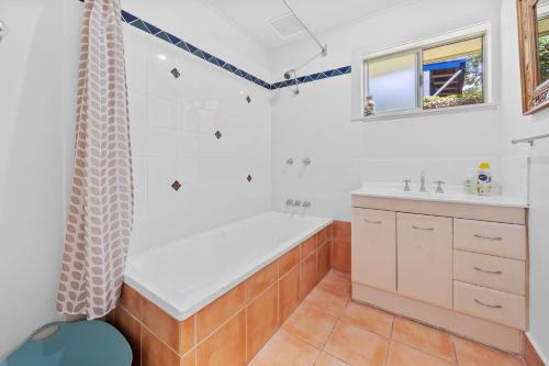 a bathroom with a tub and a sink at Dragonflies on Billa in Point Lookout