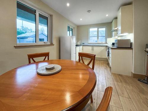 a kitchen with a wooden table and chairs in a kitchen at The Annexe - Uk51362 in Dollar