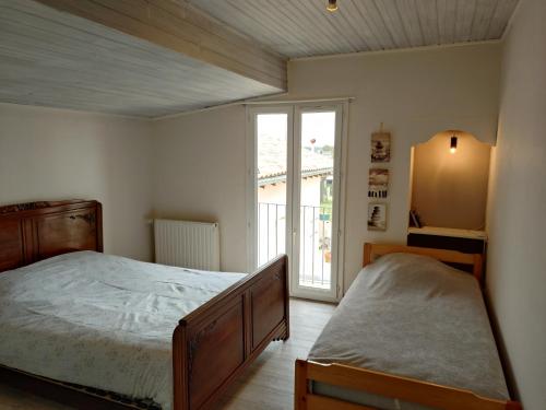 a bedroom with a bed and a window at La Maison de l'Ormeau in Montauban