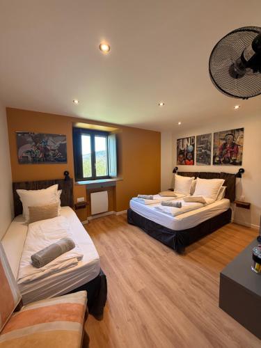 a large room with two beds and a couch at Au Pont d’Olt in Saint-Côme-dʼOlt
