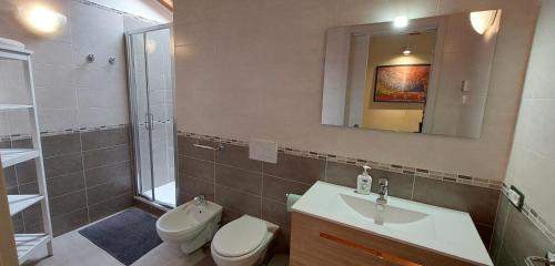 a bathroom with a sink and a toilet and a mirror at B&B Happy Guest in Caprino Veronese