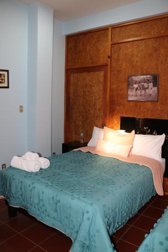 a bedroom with a large bed with a wooden headboard at Hacienda Casa de Piedra in Tlacolula de Matamoros