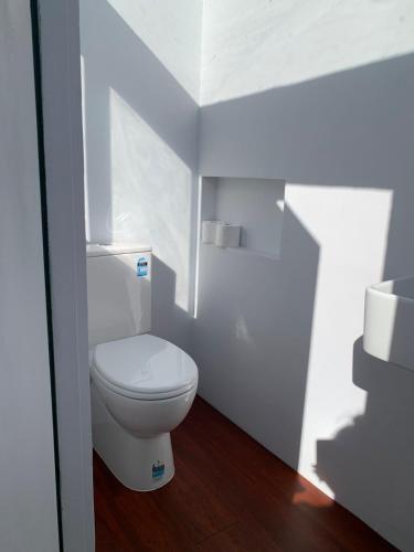 a white bathroom with a toilet and a sink at Kangaroo Island A-Frame Off-Grid Escape in Pelican Lagoon