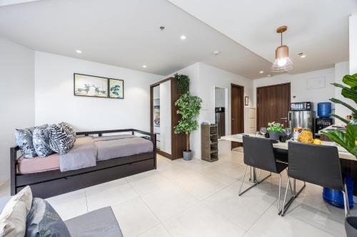 a bedroom with a bed and a dining room at Studio for 5 at Tambuli Residences Garden View by Dominik Studio Apartment with Pool Access & Balcony in Mactan in Maribago