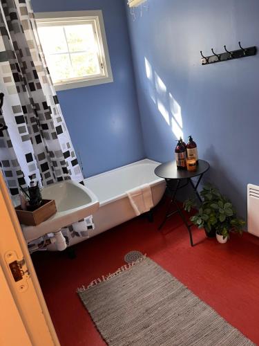 a bathroom with a bath tub and a table at Fjellhytte Rauland in Austbø