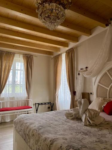 a bedroom with a large bed with a chandelier at ROSETO HOLIDAYS AZZURRO in Cavalcaselle