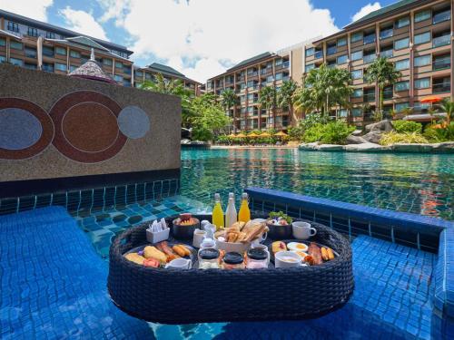 a buffet of food in a pool at a resort at Novotel Phuket Vintage Park Resort in Patong Beach