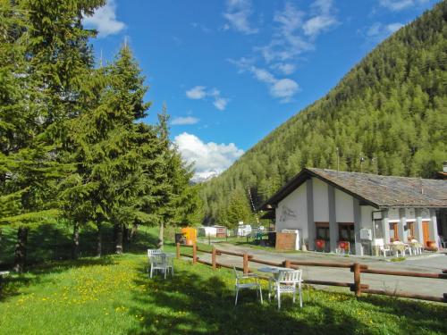 a building with chairs in front of a mountain at Chez Nous in Saint-Oyen