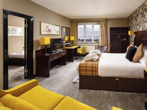 a hotel room with a large bed and a desk at Mercure Ayr Hotel in Ayr