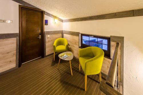 a room with two chairs and a table and a window at Chalet CrepDeChine Hotel in Bukovel