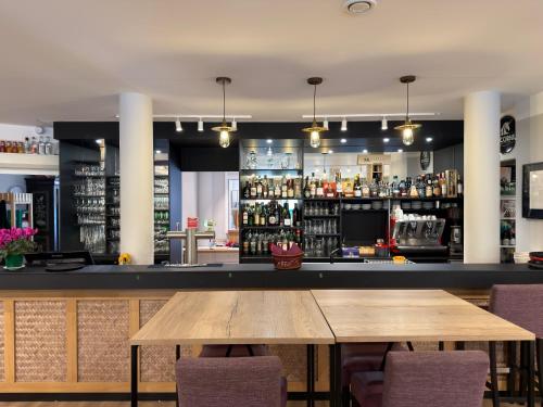 un bar con tavolo e sedie in legno di Hotel Ecluse 34 a Steinbourg