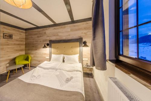 a bedroom with a white bed and a window at Chalet CrepDeChine Hotel in Bukovel