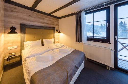 a bedroom with a large bed and a large window at Chalet CrepDeChine Hotel in Bukovel