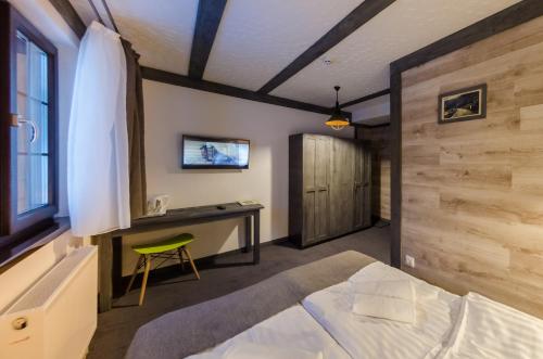 a bedroom with a bed and a desk with a computer at Chalet CrepDeChine Hotel in Bukovel