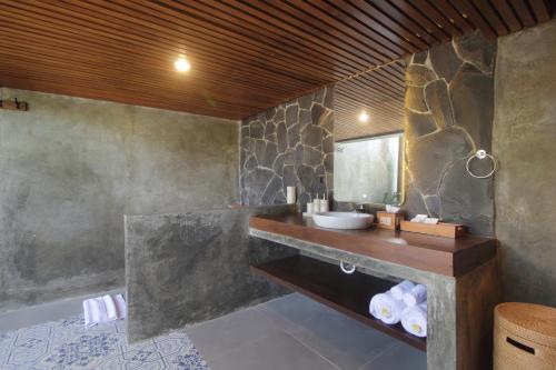 a bathroom with a sink and a mirror at Babakan Hill Villas in Jasri