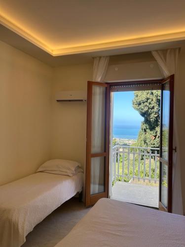 two beds in a room with a view of the ocean at Dream on the Blue House in Valderice