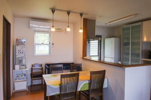 a kitchen and dining room with a table and chairs at 4BR 6人ok 空港15分 ビーチ10秒 BBQ in Akagina