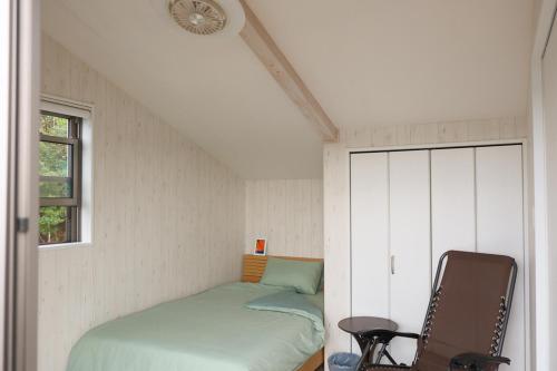 a small bedroom with a bed and a window at 4BR 6人ok 空港15分 ビーチ10秒 BBQ in Akagina