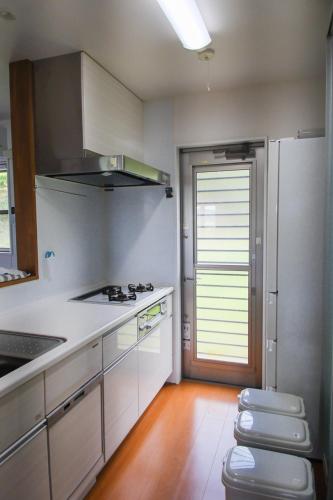 a kitchen with a sink and a stove top oven at 4BR 6人ok 空港15分 ビーチ10秒 BBQ in Akagina