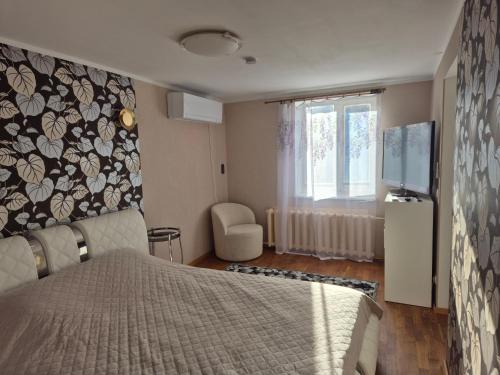 a bedroom with a bed and a tv and a window at Mäe Apartment in Tartu