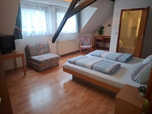 a large bedroom with a bed and a chair at Weingasthaus zum Fährhof in Winningen