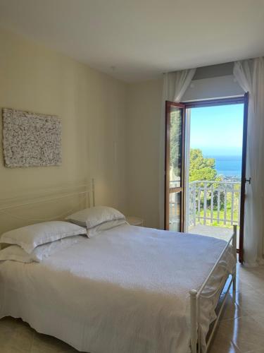 a bedroom with a bed and a view of the ocean at Dream on the blue house 2 in Valderice
