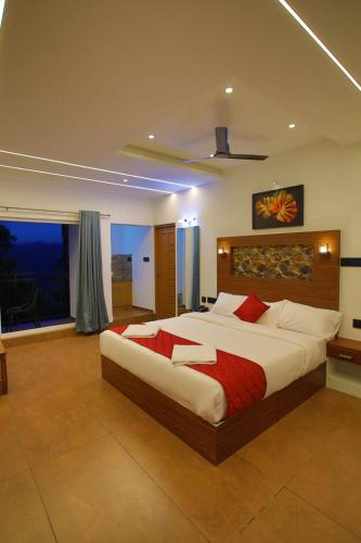 a large bedroom with a large bed with red pillows at Nature Shade Pool Villa in Anachal