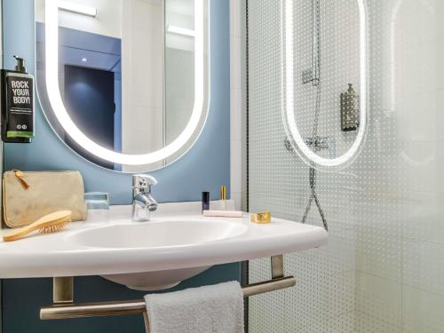 a bathroom with a white sink and a shower at ibis Bordeaux Saint Emilion in Saint-Émilion
